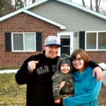 Photo of Mike & Shannon in front of the new home that they were able to purchase with the lump sum they received from liberty settlement funding.